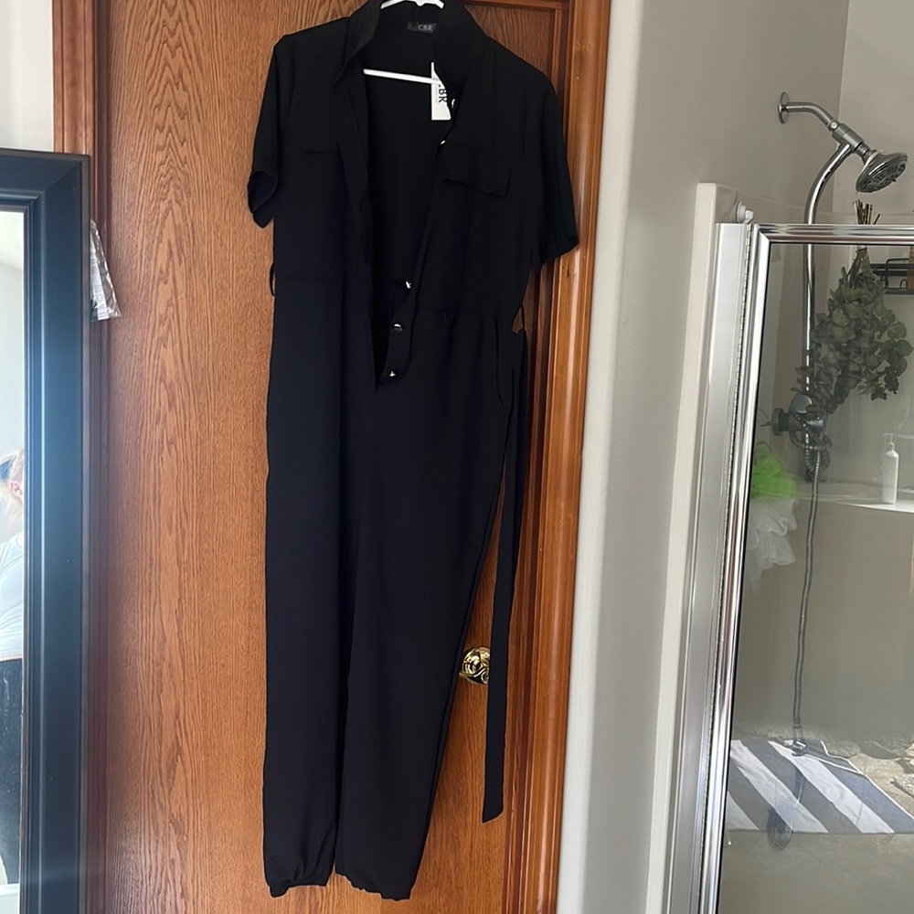 Black jumpsuit with belt. Short sleeve button on front with elastic angle.